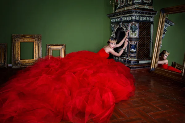 Красива дівчина в довгій червоній сукні і в королівській короні — стокове фото
