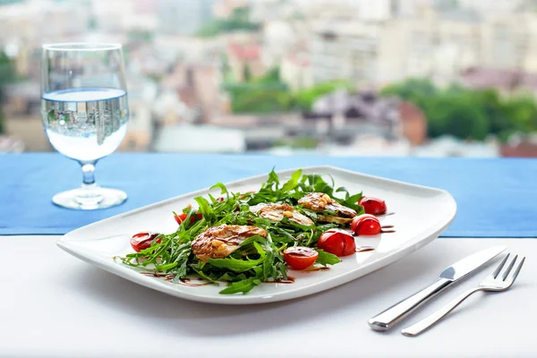 Salada com enguia, rúcula, tomate cereja e pinhões em tábua de madeira isolada sobre fundo branco — Fotografia de Stock