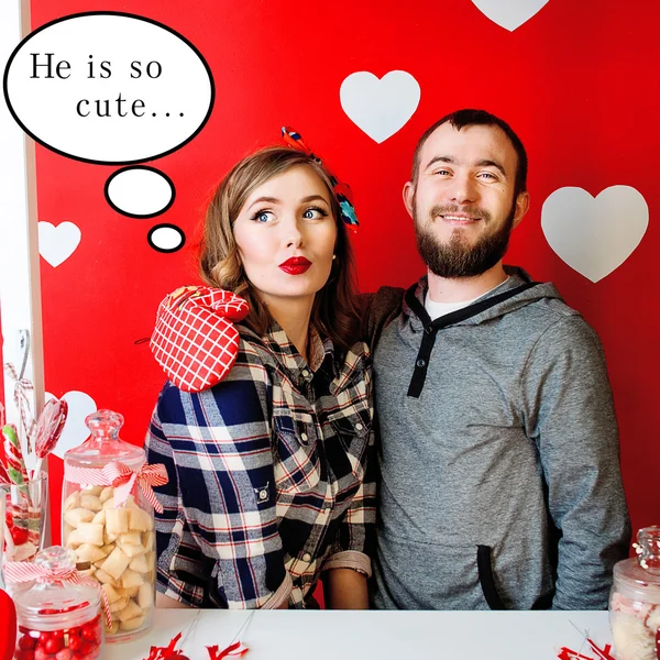 Joven hombre sonriente abrazando Hermosa mujer joven en estilo pin-up en rojo con el fondo de corazones blancos —  Fotos de Stock