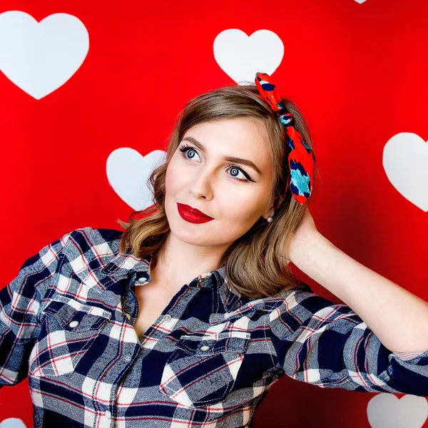 Gyönyörű fiatal nő, pin-up stílus a vörös, fehér szívek háttér — Stock Fotó
