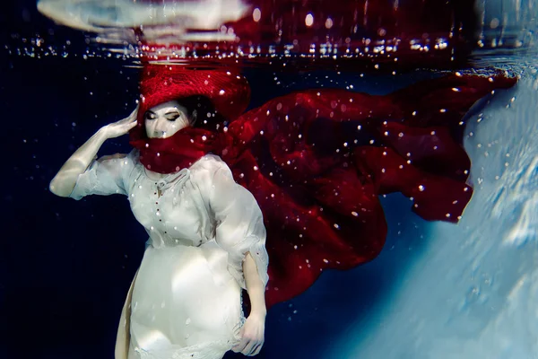 Дівчина в червоній шапці під водою — стокове фото