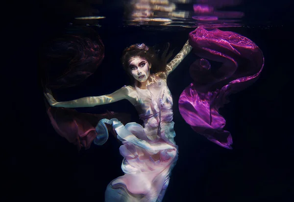 Sualtı Yüzme koyu arka plan üzerinde renkli giysili kızı