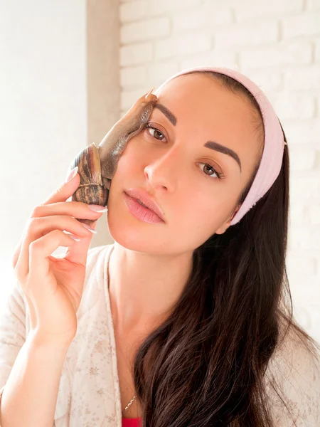 Portrait of young darkhaired woman with snails achatina giant on her face — Stock Photo, Image