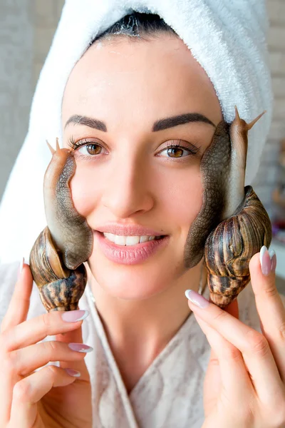 Portret van jonge lachende darkhaired vrouw met slakken achatina reus op haar gezicht — Stockfoto