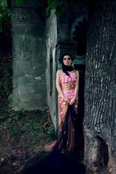 Портрет дівчини в рожевій сукні і чорна завіса біля могили на цвинтарі — стокове фото