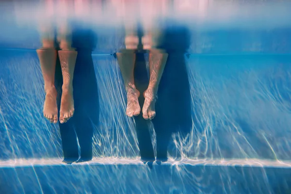 Adultes jambes dans la journée ensoleillée dans la piscine sous-marine — Photo