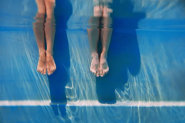 Adults legs in sunny day in the swimming pool underwater — Stock Photo, Image