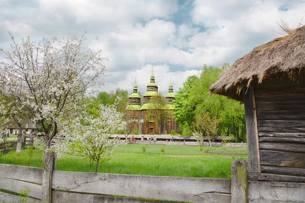 Chirch en bois et des arbres en fleurs dans le village historique national de faucons ukrainiens en plein air à Kiev — Photo