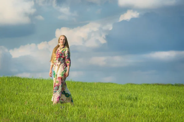 Menina loira bonita nova com cabelo longo no campo verde na aldeia étnica ao ar livre Pirogovo em Kiev Ucrânia — Fotografia de Stock