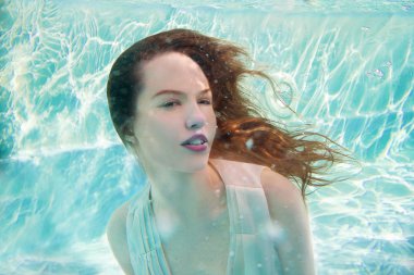 Genç gülümseyen güzel yüzme havuzunda sualtı elbiseli kadın beyaz