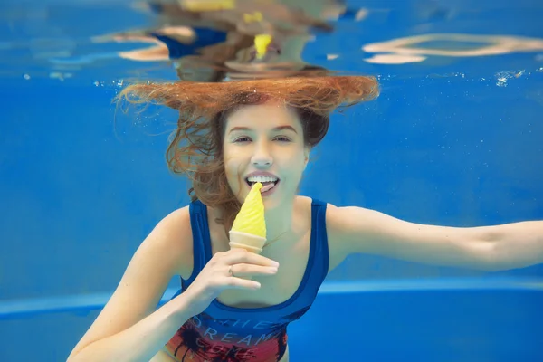 Mooi lachende rood haar meisje geel ijs eten in het zwembad onderwater in de zomer — Stockfoto