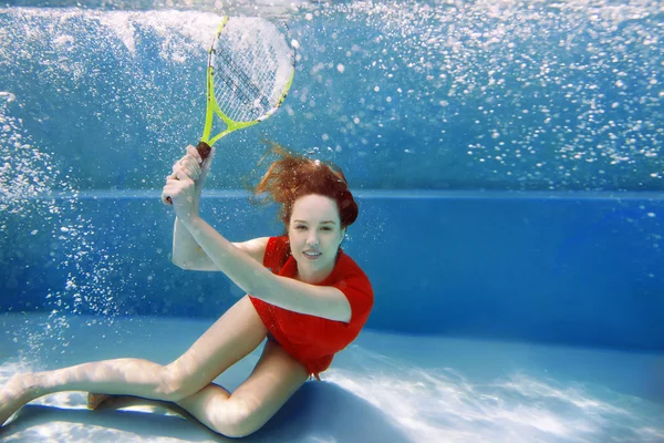 Joven hermosa chica jugando tenis bajo el agua en la piscina — Foto de Stock