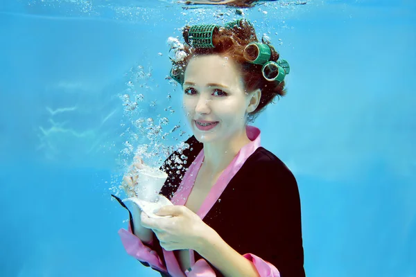 Νεαρό κορίτσι σε ένα μπουρνούζι και σίδερα υποβρύχια στην πισίνα — Φωτογραφία Αρχείου