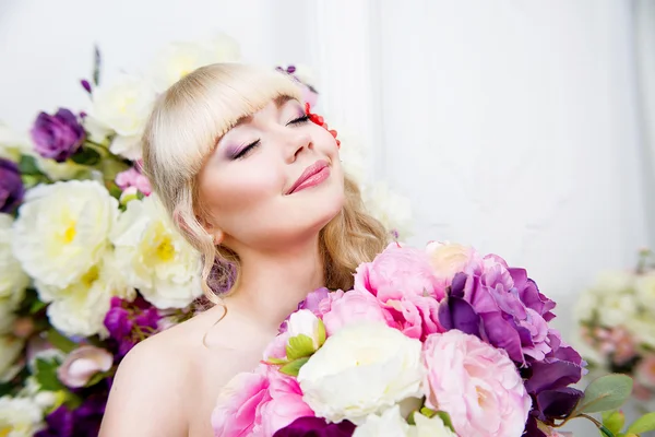 Ung flicka stående i vårblommor — Stockfoto