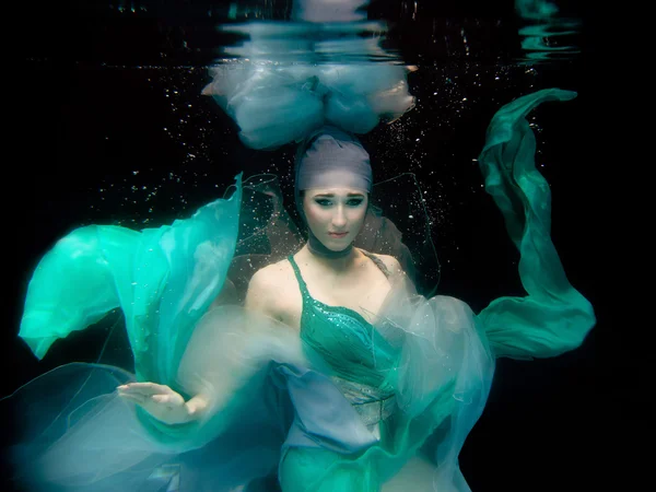 Mädchen in grünem Kleid unter Wasser — Stockfoto