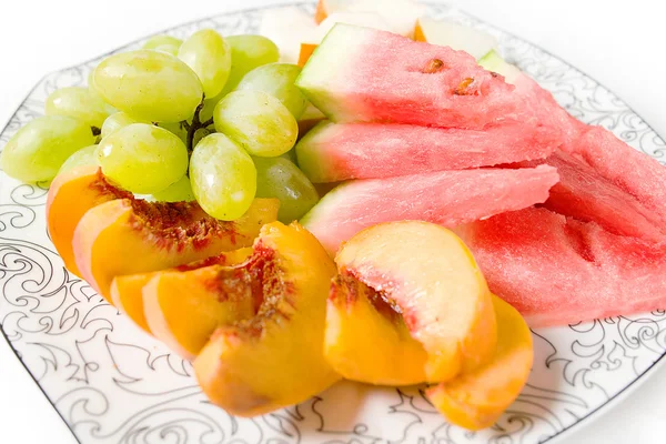 Pêssego, uva branca, melancia e melão no prato — Fotografia de Stock