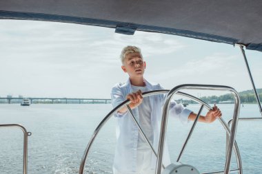 Beyaz tişörtlü, yelkenli yatlı, ciddi sarışın çocuk. Eğitim, dersler, öğrenim, beceriler, büyüme kavramı