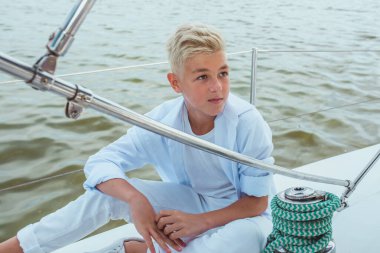 Yatta beyaz tişörtlü ve tişörtlü yakışıklı bir genç. Eğitim, dersler, öğrenim, beceriler, büyüme kavramı