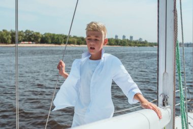 Yatta beyaz tişörtlü ve tişörtlü yakışıklı bir çocuk şarkı söylüyor. Eğitim, dersler, öğrenim, beceriler, büyüme kavramı