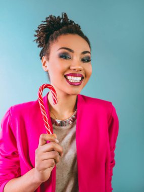 Şeker kamışlı neşeli ve mutlu Afro-Amerikan kadın. Noel, yeni yıl, şeker, mutluluk, tatil konsepti