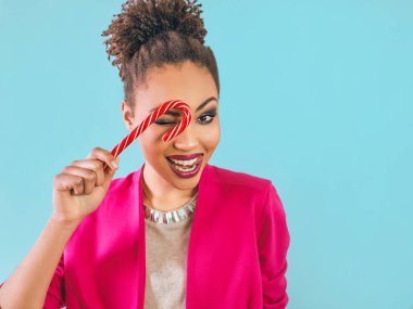 Şeker kamışlı neşeli ve mutlu Afro-Amerikan kadın. Noel, yeni yıl, şeker, mutluluk, tatil konsepti