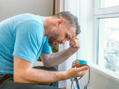 Mutsuz, şok olmuş, kronik solunum sorunu olan bir adam yatak odasında CPAP makinesini kullanarak şaşırdı. Sağlık, CPAP, uyku apnesi terapisi, horlama konsepti