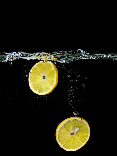 Нарезанный Лимон Падает Воду Темном Фоне Вид Водой Кулинария Кулинария — стоковое фото