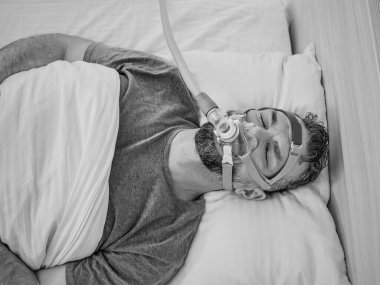 Kronik solunum sorunları olan Uyuyan Adam 'ın tek renkli portresi yatakta CPAP makinesi kullanmayı düşünüyor. Sağlık, obstrüktif uyku apnesi terapisi, CPAP, horlama konsepti
