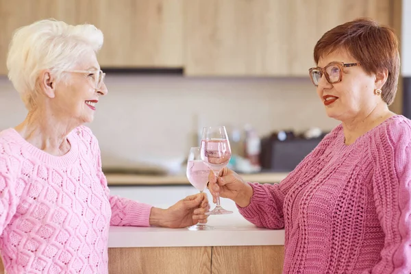 Две Стильные Женщины Розовых Свитерах Пьют Розовое Вино Современных Кухонных — стоковое фото