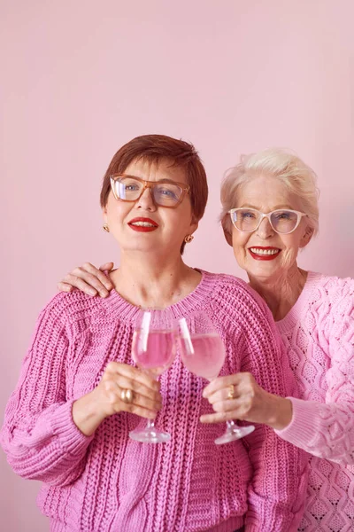 Дві Стильні Старші Жінки Рожевих Светрах Рожевими Винними Келихами Рожевому — стокове фото