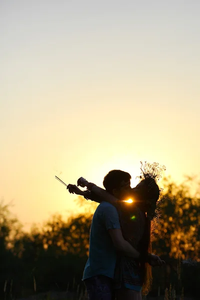 Çift aşk arka ışık siluet günbatımında dans.