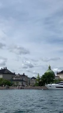 Kopenhag, Danimarka - 28 Eylül: Bir yaz gününde Nyhavn bölgesi. Su kanalı. Şehirde yeni lüks evleri olan modern ve pahalı bir yer. Kanal birçok tarihi ahşap gemiye ev sahipliği yapar..