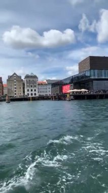 Kopenhag, Danimarka - 28 Eylül: Bir yaz gününde Nyhavn bölgesi. Su kanalı. Şehirde yeni lüks evleri olan modern ve pahalı bir yer. Kanal birçok tarihi ahşap gemiye ev sahipliği yapar..