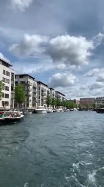 Kopenhag, Danimarka - 28 Eylül: Bir yaz gününde Nyhavn bölgesi. Su kanalı. Şehirde yeni lüks evleri olan modern ve pahalı bir yer. Kanal birçok tarihi ahşap gemiye ev sahipliği yapar..