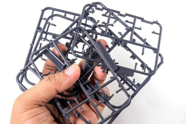 Model Kit için siyah plastik çerçeveyi tutan el. Beyaz arkaplanda izole edilmiş Robot Model Kit İnşa ediliyor