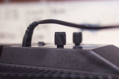 İki silindirik siyah ayar düğmesi ve üst yüzeye takılı bir güç kablosu.