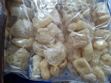 Şeffaf plastik poşetlerde paketlenmiş geleneksel çıtır balık veya deri krakerlerinin yakın plan görüntüsü