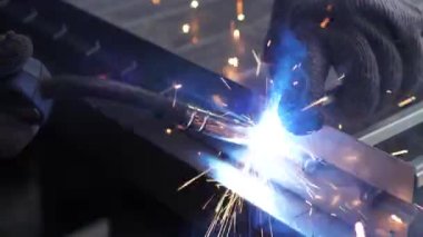 Metal çelik ve demirle yakın çekim işi kaynak makinesi, parlak kıvılcımlar ve çok yavaş çekimde yanıp sönüyor.