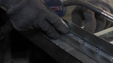 Metal çelik ve demirle yakın çekim işi kaynak makinesi, parlak kıvılcımlar ve çok yavaş çekimde yanıp sönüyor.