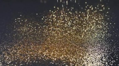Altın tozu siyah arkaplana düşer