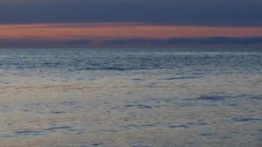 Gün batımında kıyıda küçük dalgalar, yavaş çekim