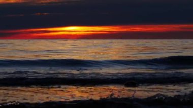 Gün batımında kıyıda küçük dalgalar, yavaş çekim