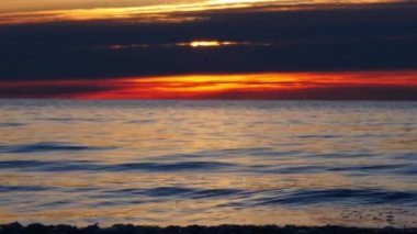 Gün batımında kıyıda küçük dalgalar, yavaş çekim