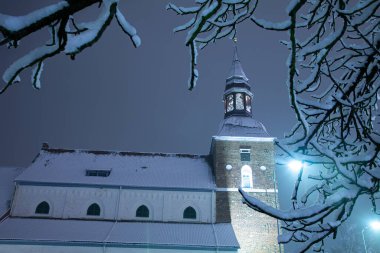Karlı ağaçlarla çekilmiş bir gece fotoğrafı. Kışın eski kilise
