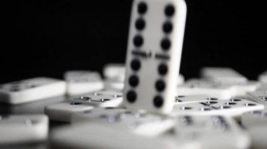 Beyaz domino zarları siyah arka plana düşer. Yavaş çekim