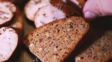 Eli olan bir adam bir dilim ekmek sosisi koyar. Küçük bir atıştırmalık. Yakından çek.