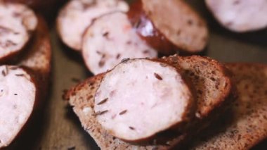 Dilimlenmiş sosis ve ekmeğe kimyon serpin. Tepsi dönüyor. Seçici odak