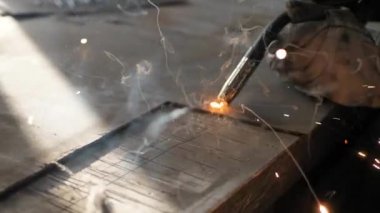 Masadaki kaynakçı bir takım metal parçaları kaynaklıyor. Kaynakçı çalışıyor. Metalle çalışmak