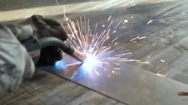Masadaki kaynakçı bir takım metal parçaları kaynaklıyor. Kaynakçı çalışıyor. Metalle çalışmak