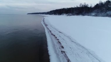 Soğuk bir kış gününde donmuş karlı deniz kıyısında. Drone görünümü
